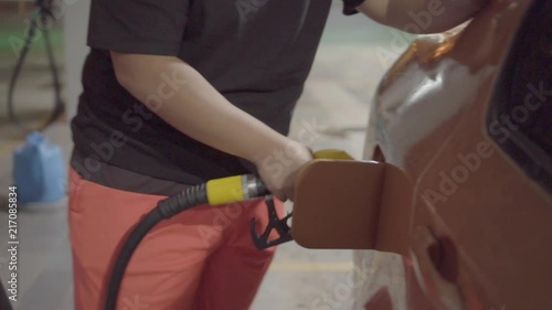 A PERSON REFUELLING AT A PERTOL STATION photo