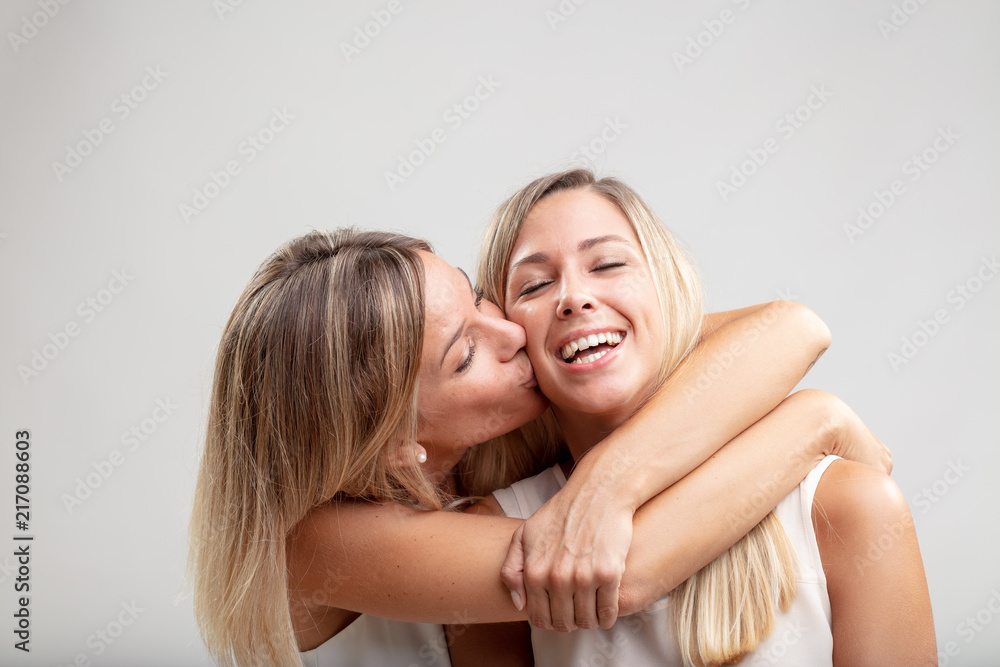Spontaneous young woman kissing her friend Spontaneous young woman kissing her friend