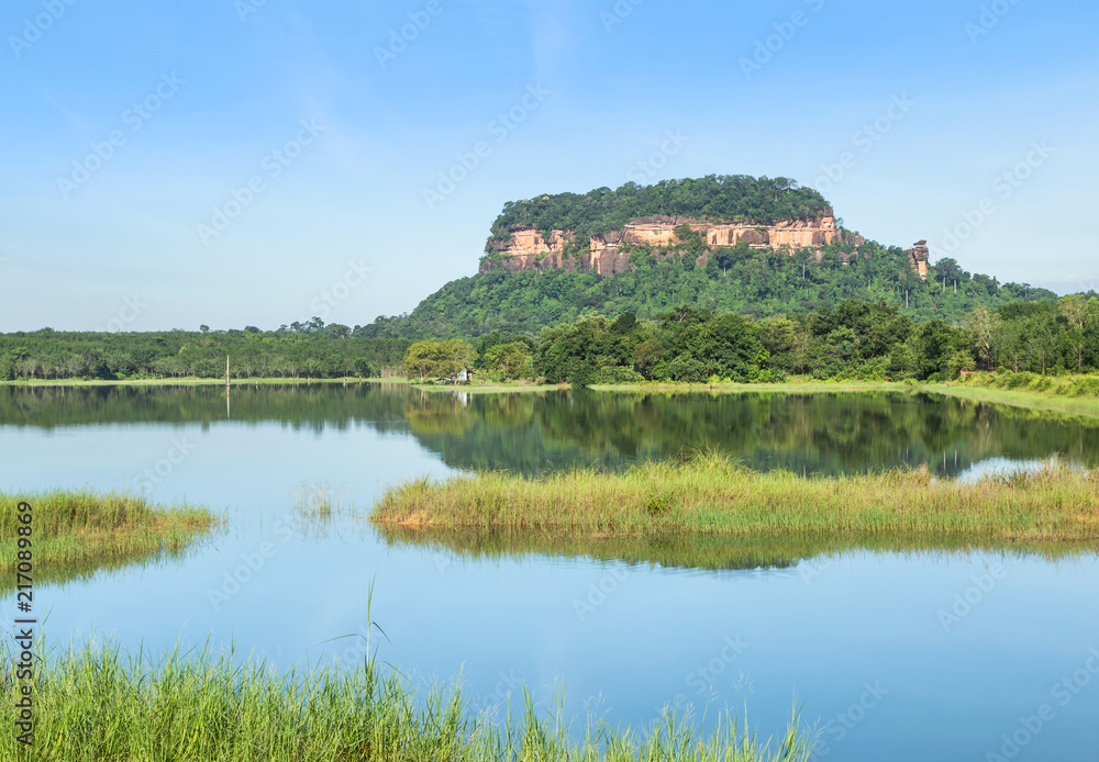 View of wat Phuthok or wat Jatiyakeeree viharn on cliff  high mountain reflection on the water in lake  with blu sky at Bueng Kan Province, Thailand     