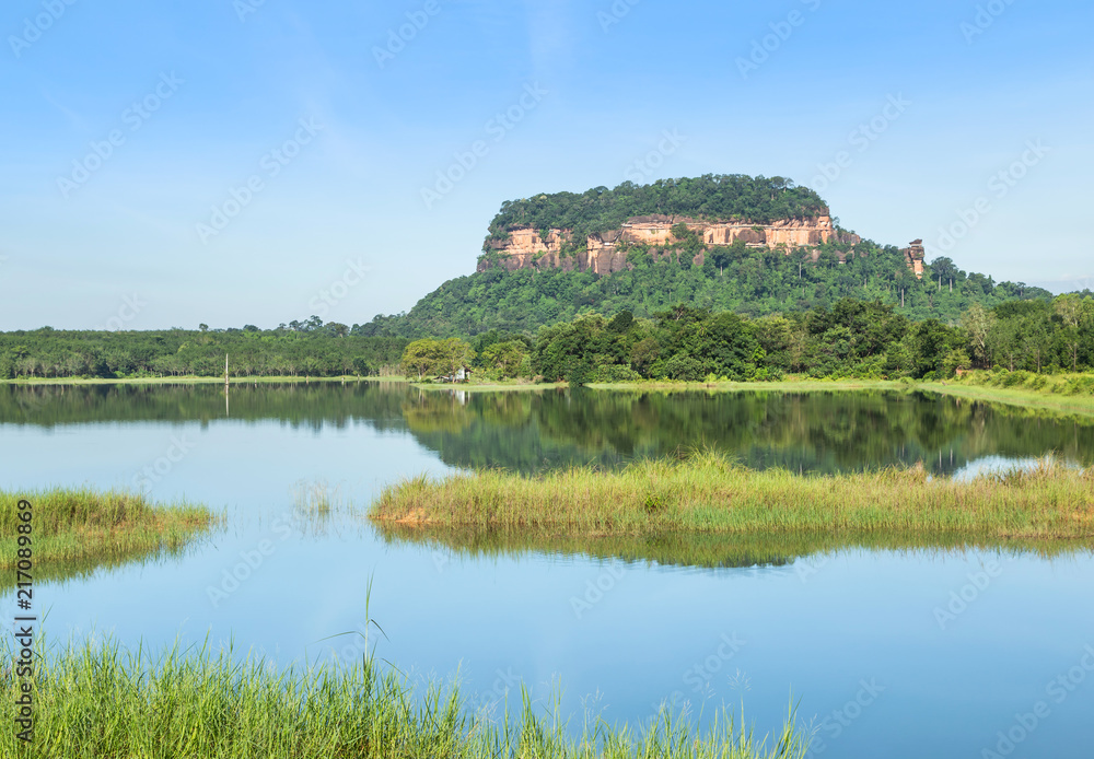View of wat Phuthok or wat Jatiyakeeree viharn on cliff high mountain reflection on the water in lake with blu sky at Bueng Kan Province, Thailand View of wat Phuthok or wat Jatiyakeeree viharn on cliff high mountain reflection on the water in lake with blu sky at Bueng Kan Province, Thailand