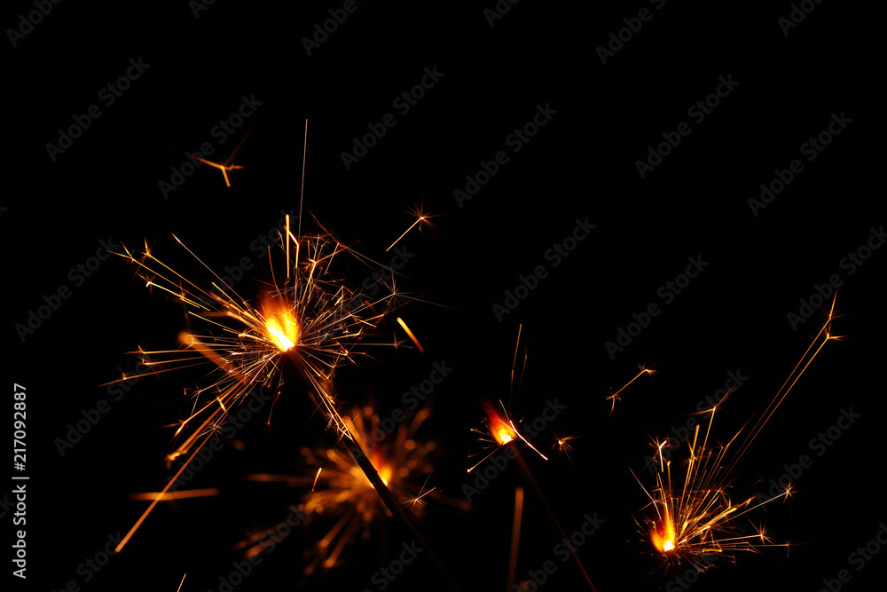 Fototapeta premium Close up several firework sparklers over black