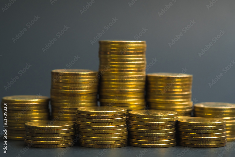 Savings, increasing columns of coins, piles of coins arranged as a graph in dark room, business banking concept. Savings, increasing columns of coins, piles of coins arranged as a graph in dark room, business banking concept.