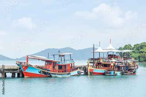 colorful Thai wooden fishing boats floating moored in coast at Koh Chang island and Trad province, Thailand