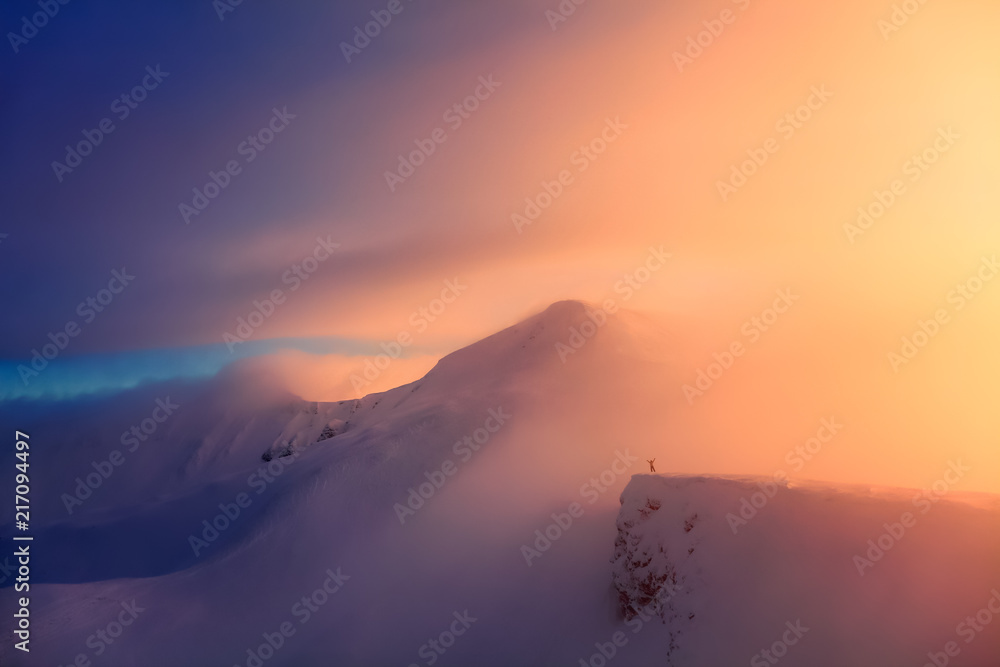 Unbelievable sunrise high at the mountains covered by snow. The free rider guy with the up raised hands is staying at the edge enjoying the scenery. Unbelievable sunrise high at the mountains covered by snow. The free rider guy with the up raised hands is staying at the edge enjoying the scenery.