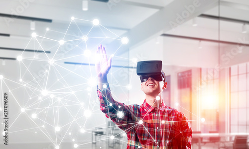 Guy wearing checked shirt and virtual mask reaching hand to touch screen