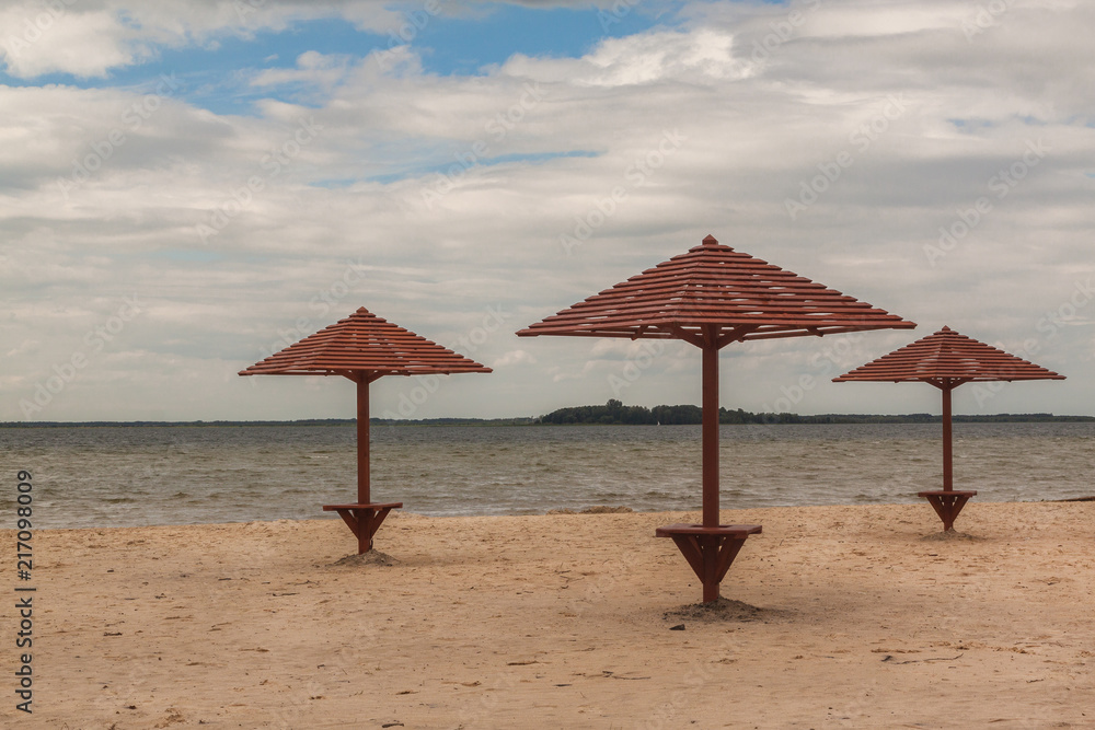 Fototapeta premium Wooden umbrellas on the beach on Lake Svitiaz