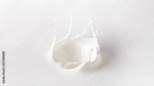 Milk Splash On White Background. Splashes of milk, splashing yogurt or cosmetic cream close-up. Template for the falling in the milk berry or a piece of fruit.
