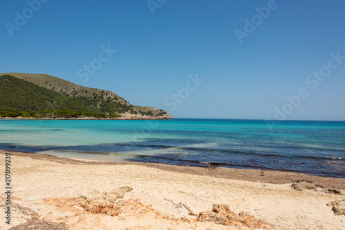 View of the turquoise Mediterranean Sea and the beautiful sandy beach of Cala Agulla on the Spanish holiday island Mallorca