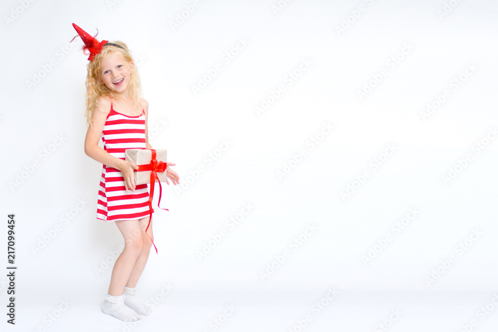 Christmas and new year card with happy cute little blonde girl in red and white carnival costume dress with gift box in hands on white background. Copyspace - holidays, winter and celebration concept Christmas and new year card with happy cute little blonde girl in red and white carnival costume dress with gift box in hands on white background. Copyspace - holidays, winter and celebration concept