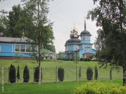 Blue wooden orthodox church with golden domes