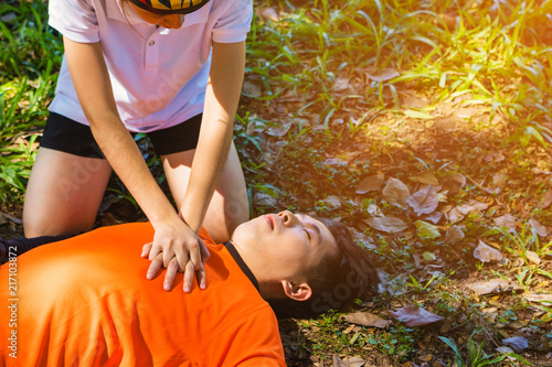 First Aid Emergency CPR. After Bicycle Race A Cyclist man has Heart Attack or Shock. A woman  give CPR for first aid Cyclist man. Emergency , safe life , Photo concept Heart Attack and CPR. 