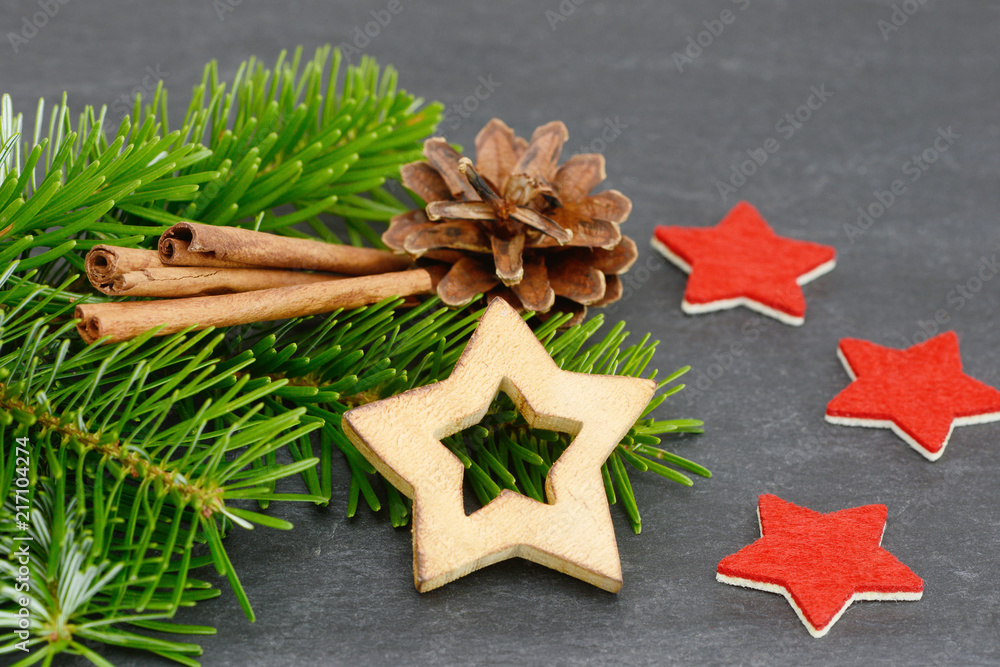 star, pinecone and cinnamon stick lying on fir branch star, pinecone and cinnamon stick lying on fir branch