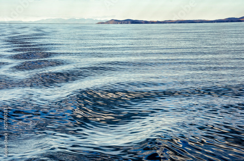 Waves on surface of water with cloudy sky