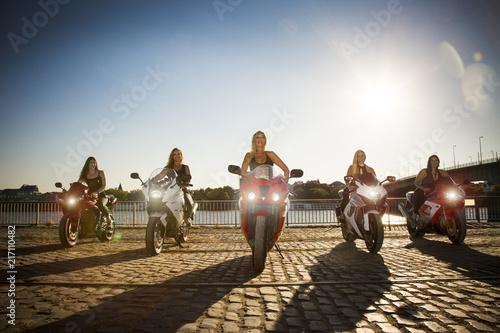 5 Frauen auf Motorrädern am Fluss. Formation.  photo