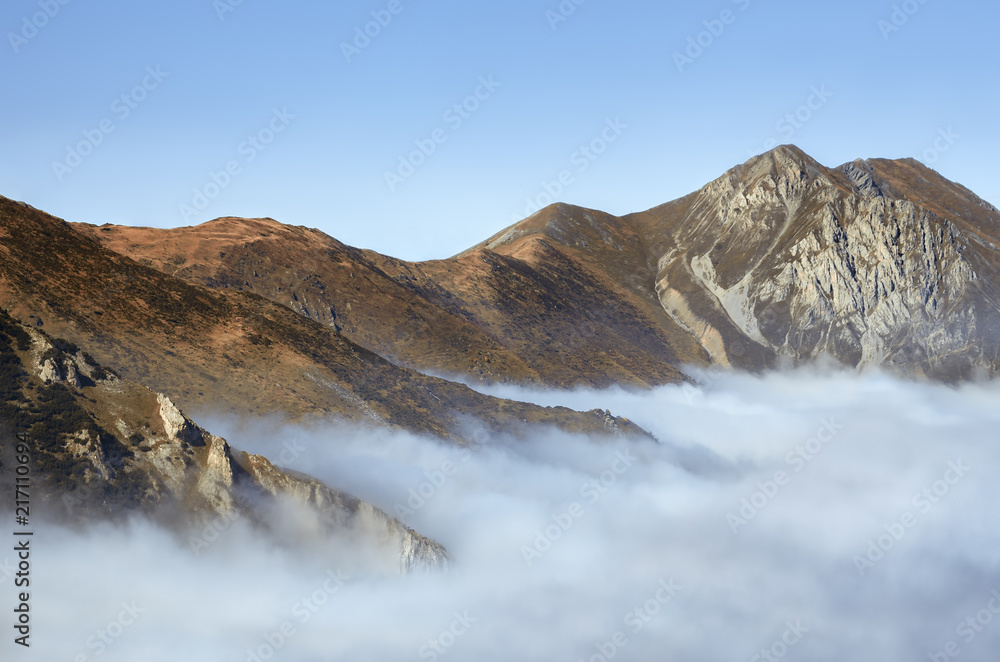 Mountain peaks emerging from the clouds on the path to the lake of Frisson, in Maritime Alps Park (Piedmont, Italy)