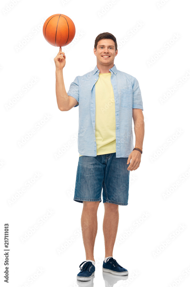 sport, leisure and basketball concept - smiling young man spinning ball on finger over white background