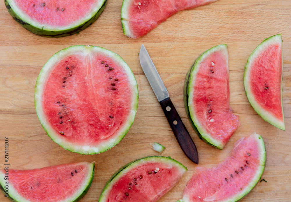 Watermelon and knife on wooden table. Above view Watermelon and knife on wooden table. Above view