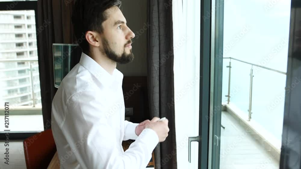 Businessman in white shirt took marker and began to write on window glass Businessman in white shirt took marker and began to write on window glass