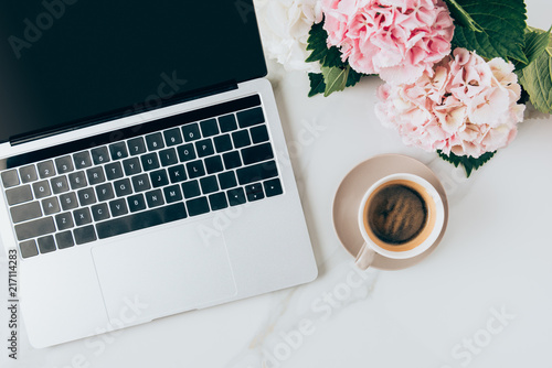 Fototapeta Naklejka Na Ścianę i Meble -  flat lay with laptop, coffee cup and hortensia flowers on marble surface