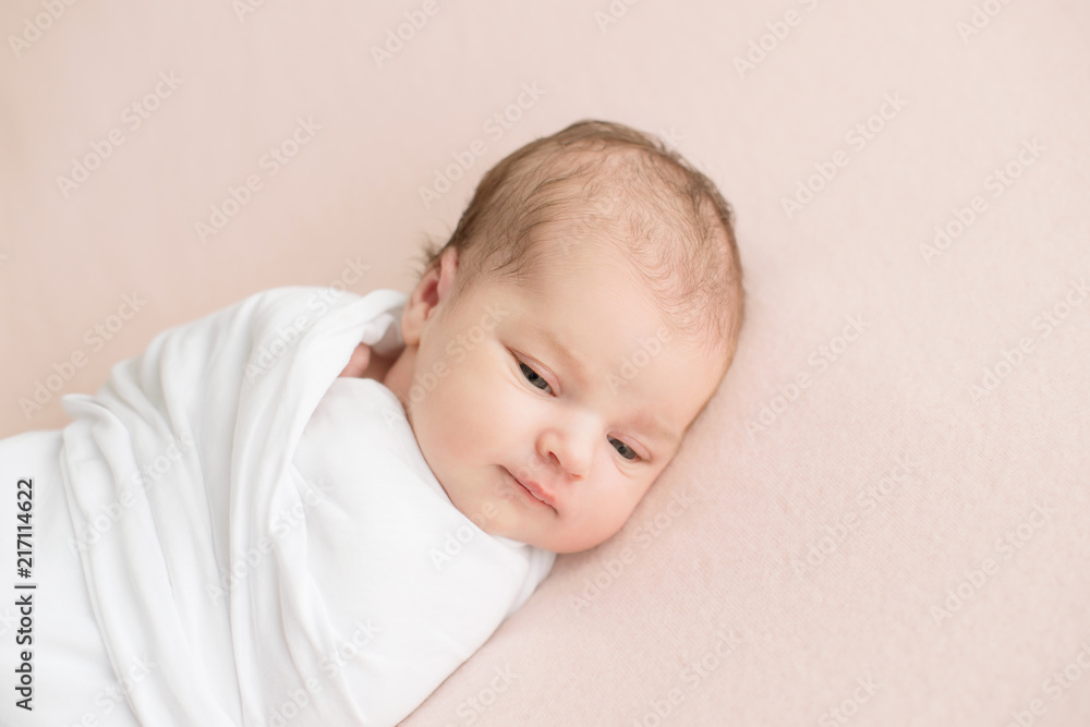 Newborn girl in white wrap on a pink background. Photoshoot for the newborn. 7 days from birth. A portrait of a beautiful, seven day old, newborn baby girl Newborn girl in white wrap on a pink background. Photoshoot for the newborn. 7 days from birth. A portrait of a beautiful, seven day old, newborn baby girl