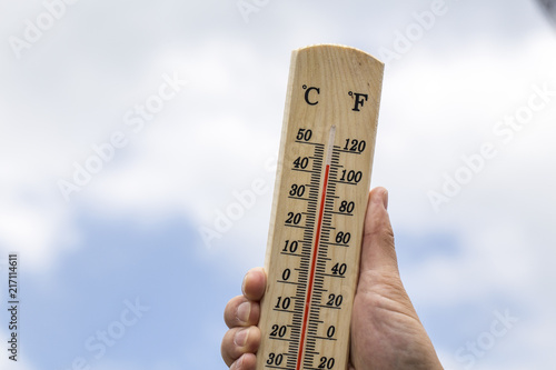 Thermometer displaying high 40 degree hot temperatures in sun summer day. photo