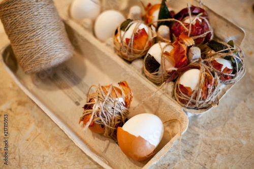 Easter tradition - boiled natural colored white and brown eggs with onions on marble table