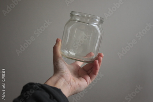 a hand holding an empty glass bottle
