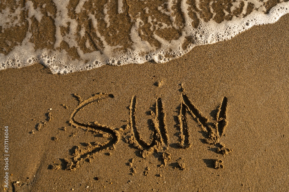 Fototapeta premium Shot of word sun written on the sand in Turkey