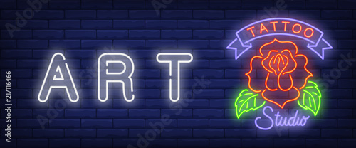 Art, tattoo studio neon text with red rose. Tattoo salon or studio concept. Advertisement design. Night bright neon sign, colorful billboard, light banner. Vector illustration in neon style.