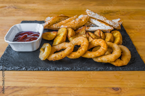 Obraz na płótnie Assorted snacks for beer in the bar. Meat, cheese, onion rings on the grill and deep-fried w salonie