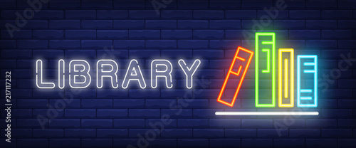Library neon text and books on shelf. Education, literature and knowledge con...