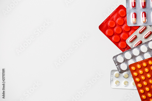 Photo of blisters with colorful tablets on empty white space.