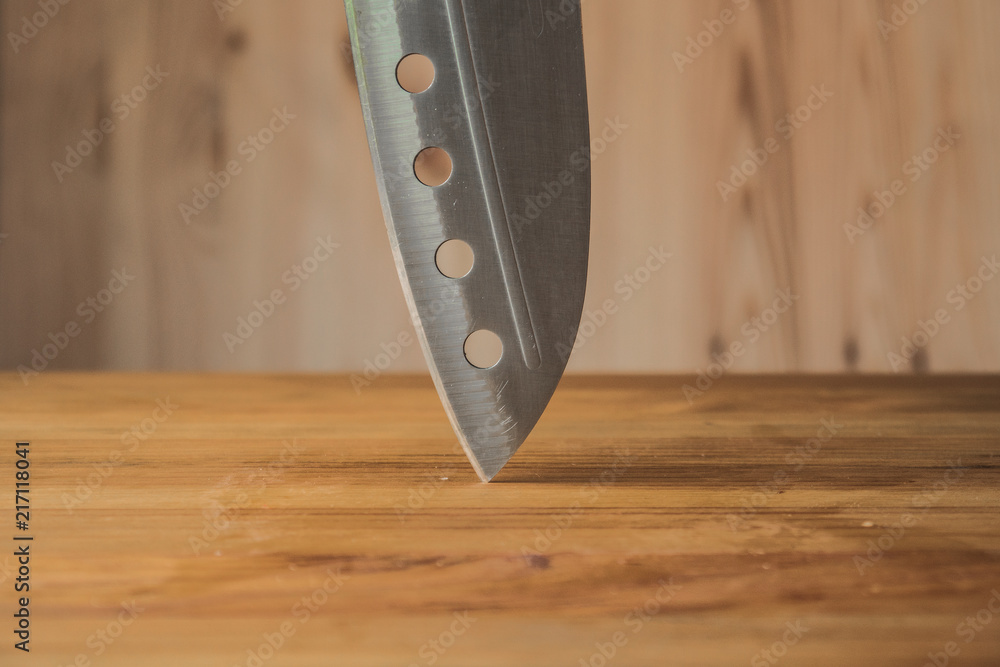 Knife on a wooden board. Stainless steel blade.