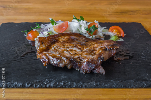 Obraz na płótnie meat with vegetables on a stone board. tomatoes. and spices, a delicious dish w salonie