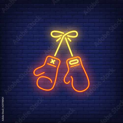 Neon icon of boxing. Protective gloves hanging on brick wall. Sport or fight club concept. Can be used for neon signs, posters, billboards, banners.
