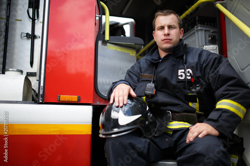 Photo of young fireman looking at camera in fire truck