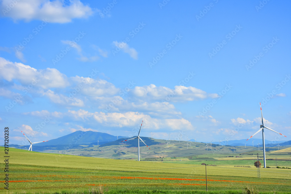 Italy, Puglia region, typical hilly landscape in spring with wind turbines.