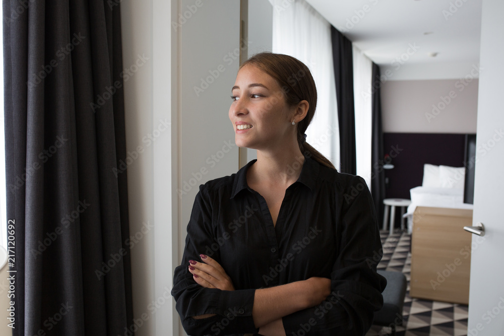 a young girl with gathered hair in a black shirt and skirt stands at the entrance to the bedroom with a white door, a young girl with gathered hair in a black shirt and skirt stands at the entrance to the bedroom with a white door,