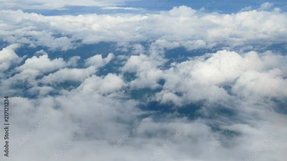 4K. aerial view through an airplane window. beautiful white clouds in blue sky background. traveling by air 4K. aerial view through an airplane window. beautiful white clouds in blue sky background. traveling by air