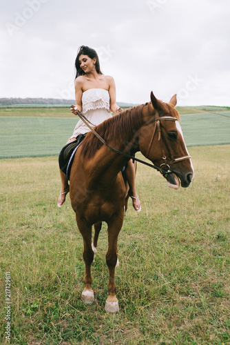 beautiful woman riding brown horse on field © LIGHTFIELD STUDIOS