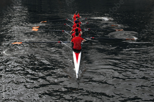 rowers rowing in the dark water. The concept of team sports