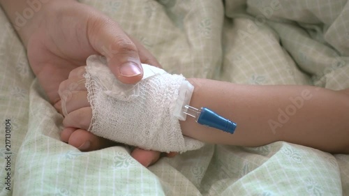 Mother holding hand of his daughter was sick in the hospital.