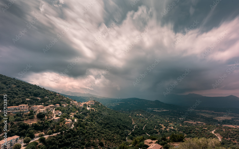 Storm clouds over the mountain village of Belgodere in Corsica