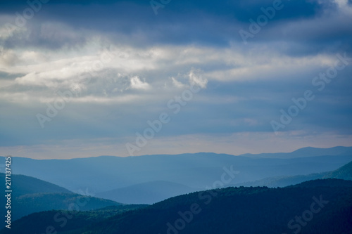 The sun s rays penetrate the clouds in the mountains