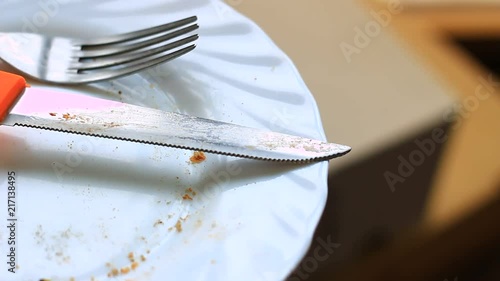 Knife, fork and food scraps on a plate. photo