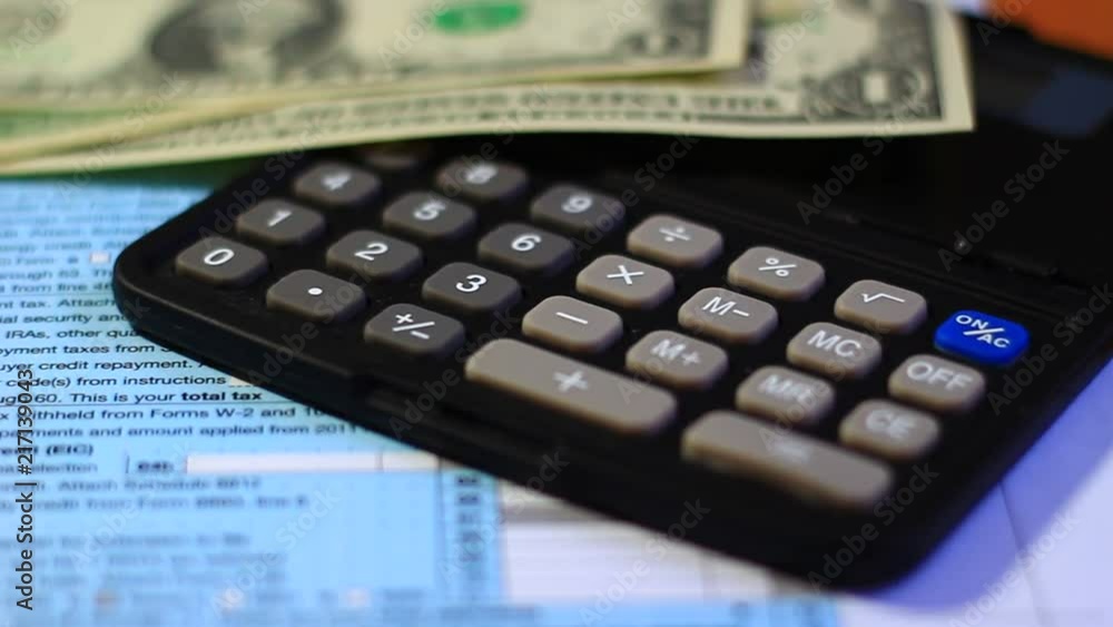 Concept of paying taxes; tax document, paper money and calculator on the desk. Concept of paying taxes; tax document, paper money and calculator on the desk.