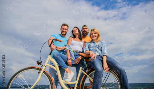 Group friends hang out with bicycle. Youth likes cruiser bike. Cycling modernity and national culture. Company stylish young people spend leisure outdoors sky background. Bicycle as best friend