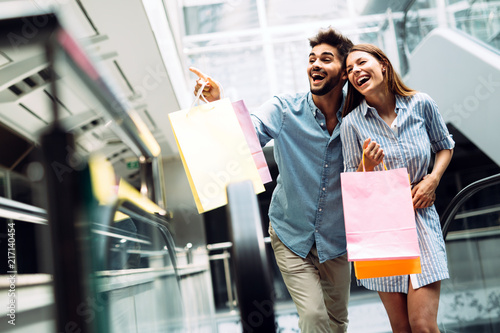 Happy attractive loving couple enjoy shopping together