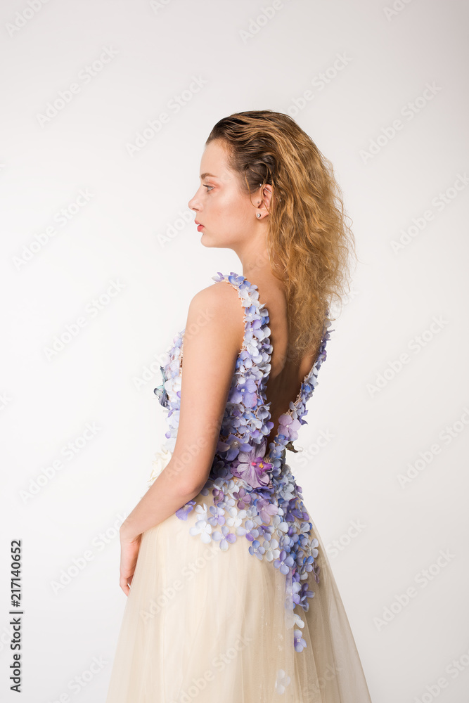 Studio portrait of blooming gorgeous lady in dress of flowers. Fashion concept