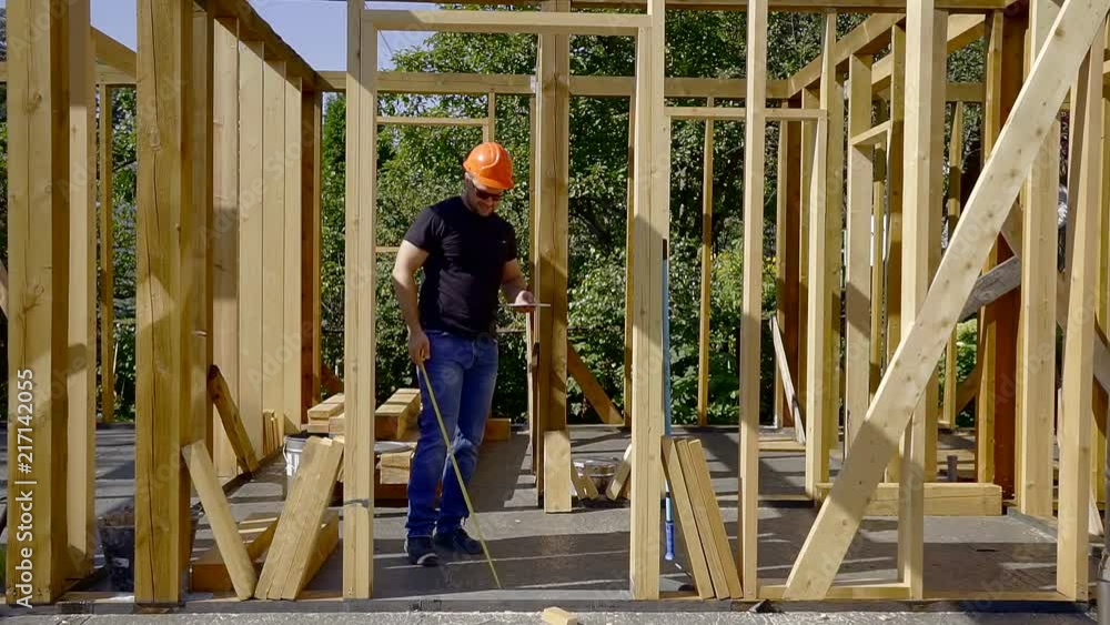 foreman is checking support of doorway in a new house under construction, applying building level foreman is checking support of doorway in a new house under construction, applying building level